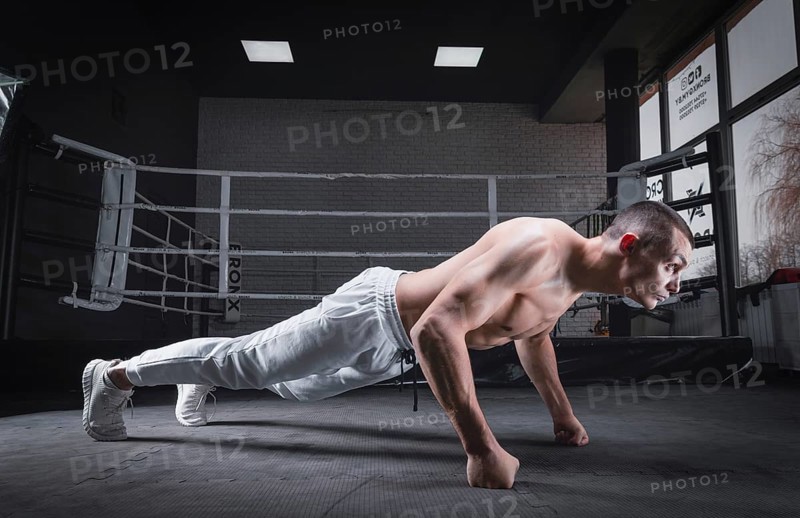 Muscular man doing push-ups in the gym. Fitness concept.