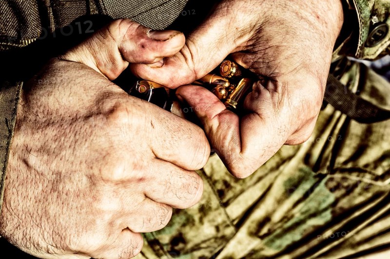 The fighter prepares a clip with bullets before the next fight.