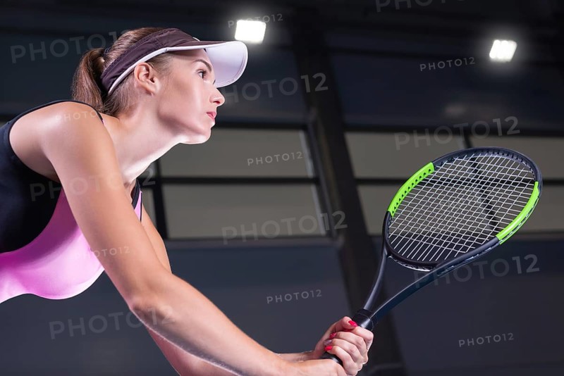 Portrait of a beautiful tennis player in a pink dress on the court. Sports concept.