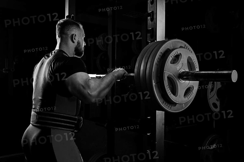 Professional athlete prepares to squat with a barbell.