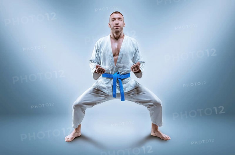 Professional wrestler is wearing a kimono. He is preparing to demonstrate the kata. The concept of mixed martial arts