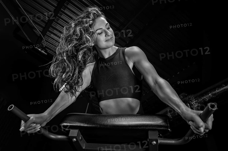 Charming brunette doing hyperextension in the gym. Press pumping. Fitness and bodybuilding concept.