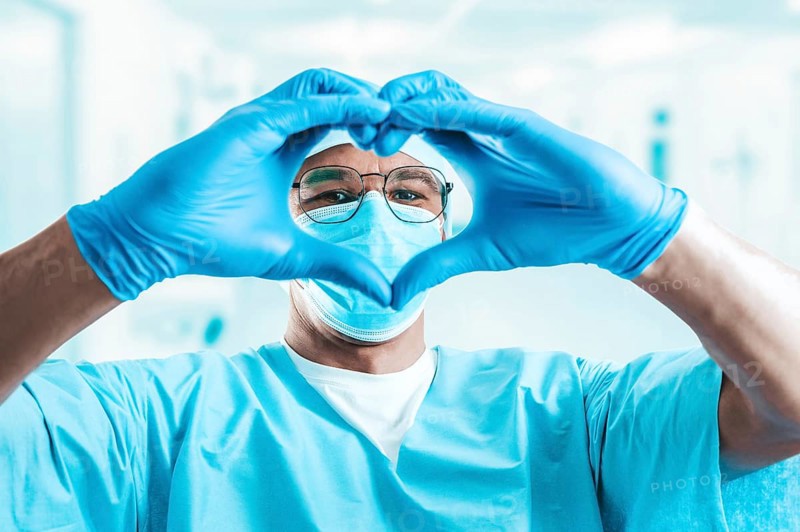 Portrait of a doctor in a hospital. He folded his hands in the shape of a heart. Medicine concept.