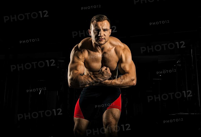 The weightlifter is posing in front of the camera