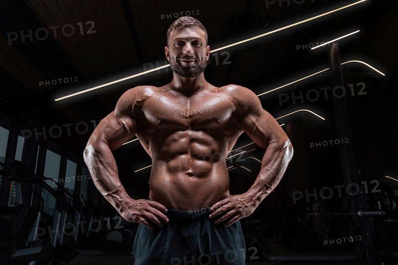 Image of a muscular guy with a naked torso and abs. Gym. Fitness concept