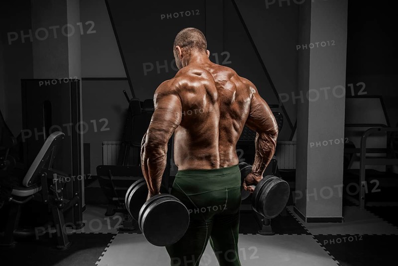 Professional weightlifter is training in the gym. Back exercises. Bodybuilding concept.