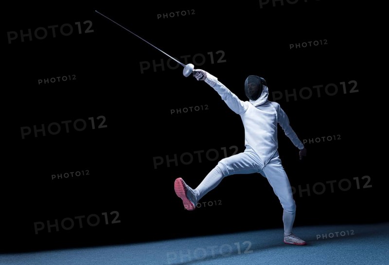The fencer moves forward with a sword in his hand. Sport concept.