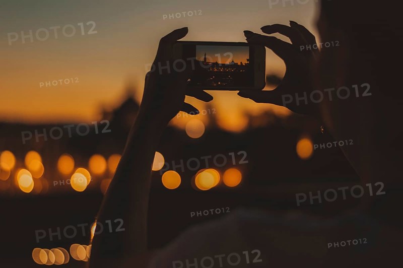 Hands of a girl holding a phone. She takes pictures of Santa Maria Del Fiore. The concept of tourism