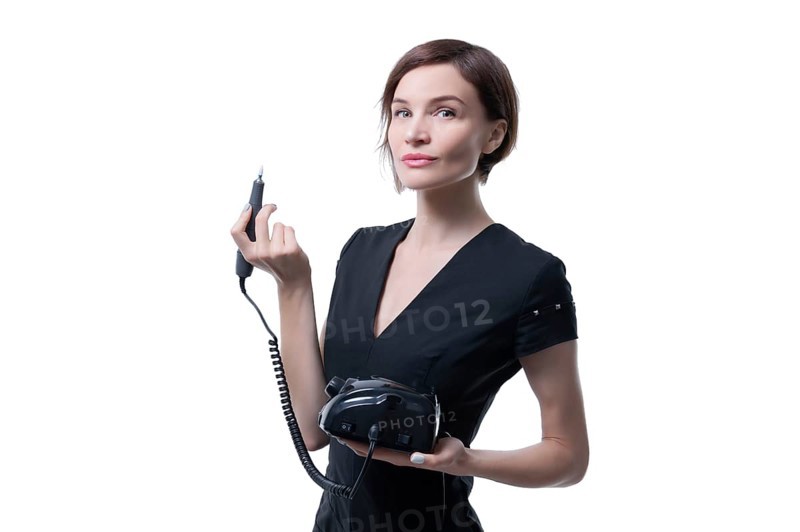 Portrait of a charming woman with a manicure device. Manicure and pedicure concept. Nails artist