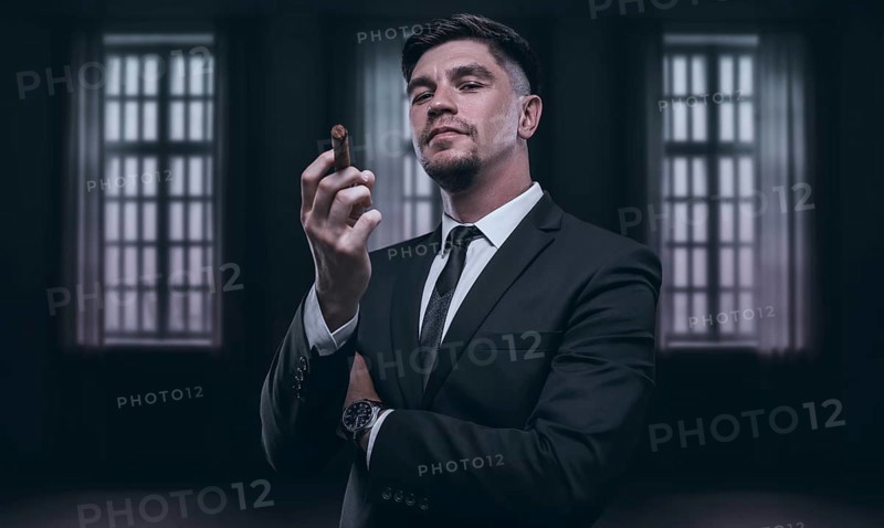 Portrait of a stylish man in a suit with a cigar. Business concept.