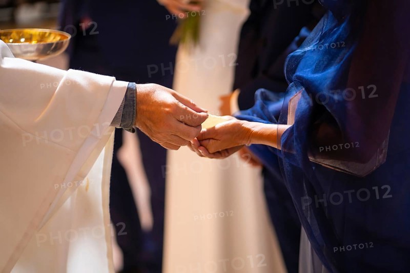 Priest at a wedding at the ceremony gives bread to the bride and groom at the wedding