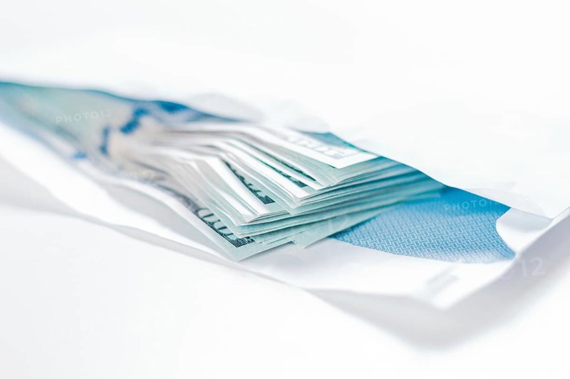 Pack of hundred-dollar bills lies in an envelope. The concept of bribery and corruption.