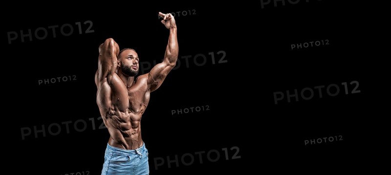 Isolated muscular man on a black background. Bodybuilding and fitness concept. Panorama.
