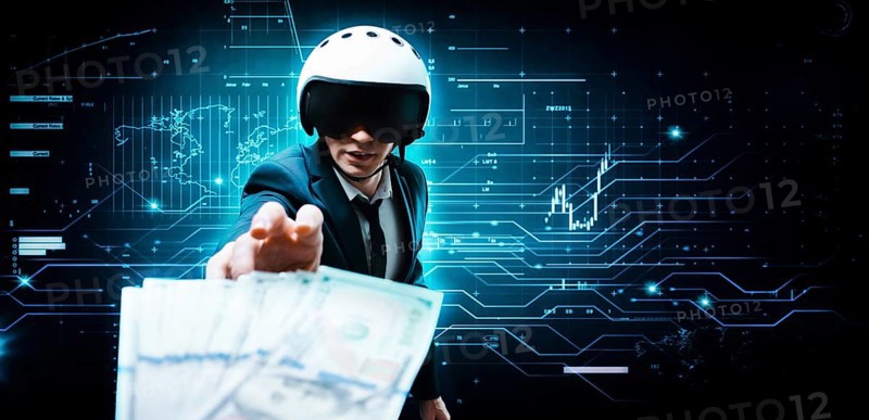 Portrait of a businessman in a suit and aviator helmet. He is trying to reach a pack of hundred-dollar bills. Business concept.