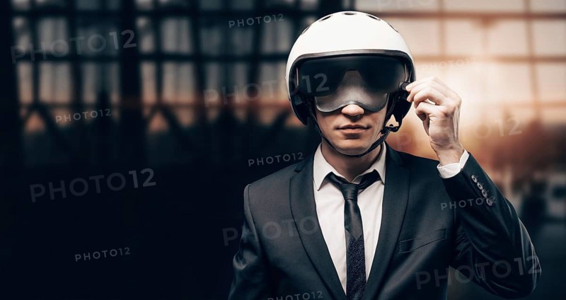 Portrait of a man in a helmet and a mask for sleeping stands at the airport. He picks up the visor. Airline concept. Caring for passengers.