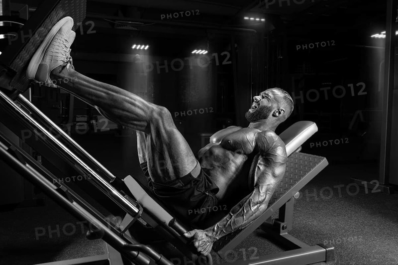 Professional athlete performs a leg exercise. Bodybuilding