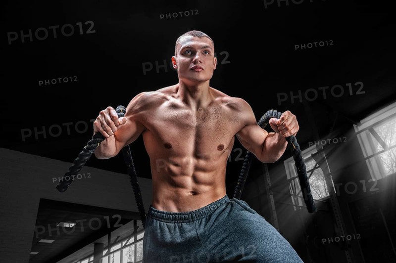 Portrait of an athlete who pulls the ropes. View from below. The concept of sport and healthy lifestyle.