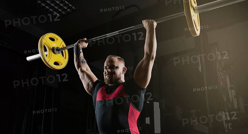 Weightlifter does an exercise with a barbell. Barbell above the head