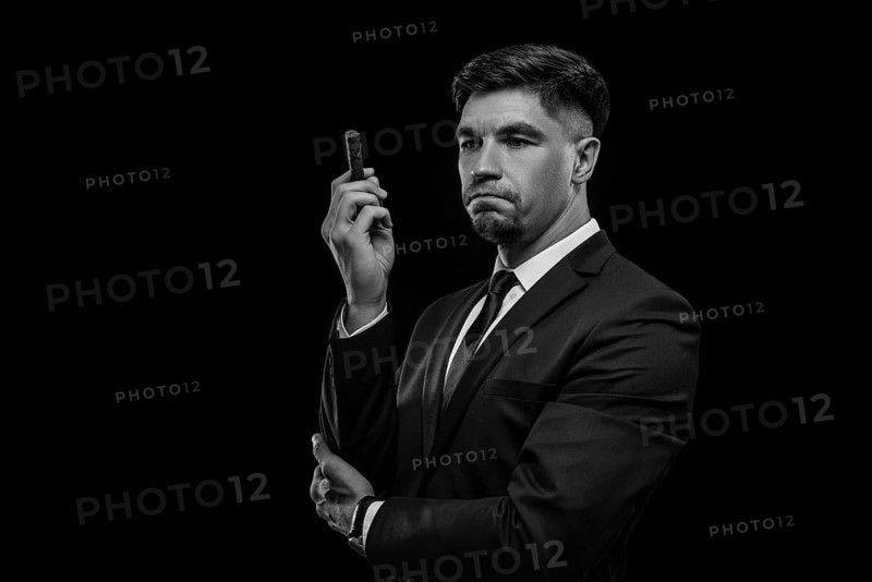 Portrait of a stylish man in a suit with a cigar. Business concept.