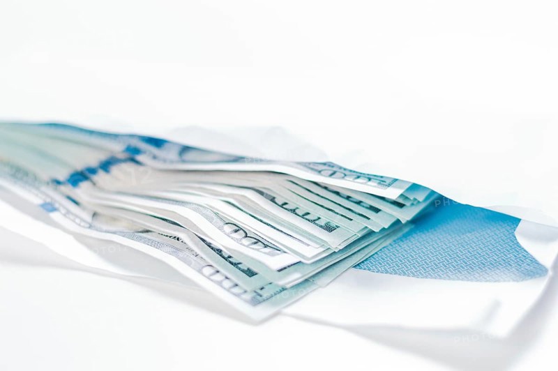 Pack of hundred-dollar bills lies in an envelope. The concept of bribery and corruption.