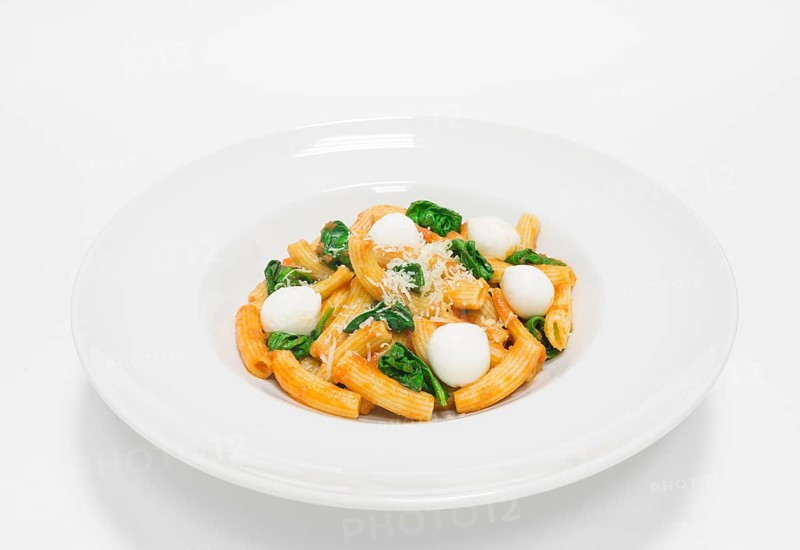 Gourmet pasta with basil and mozzarella balls. Top view. White background. Healthy eating concept.