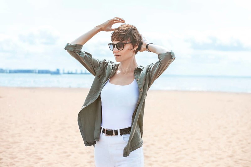 Image of a beautiful woman on the beach of the Gulf of Finland in St. Petersburg. Windy weather. Happiness