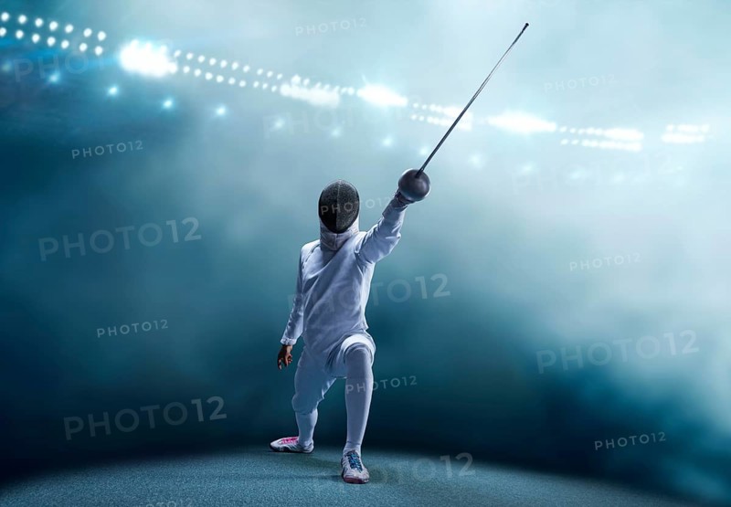 The fencer moves forward with a sword in his hand. Sport concept.