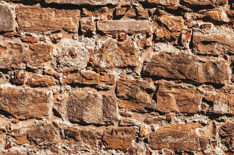 Wallpaper of a stone wall. Ancient slightly destroyed stone. Florence.