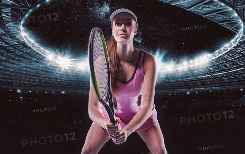 Portrait of a tennis player in a pink dress against the background of a sports arena.