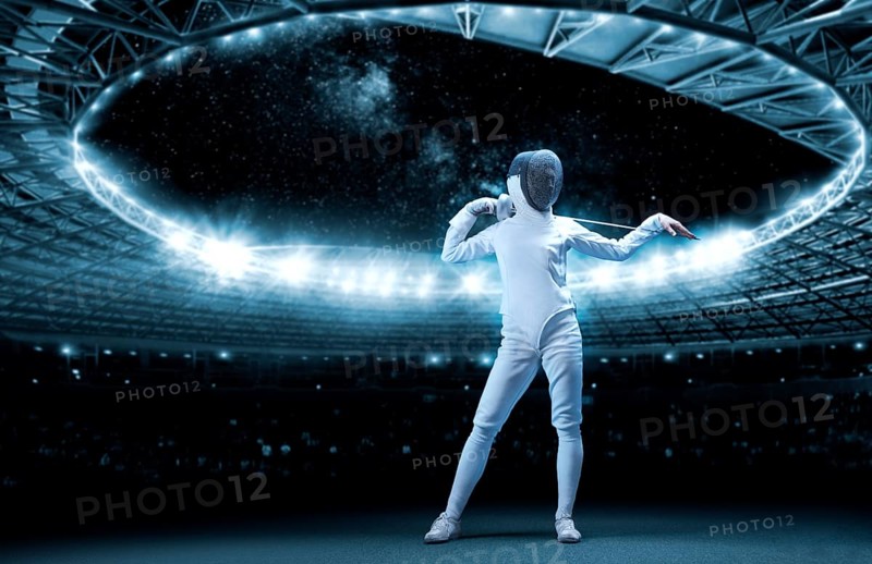 Portrait of a fencer against the backdrop of a sports arena. The concept of fencing.