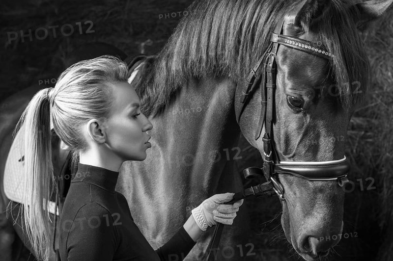 Stunning blonde posing with a thoroughbred horse. Ranch vacation concept.
