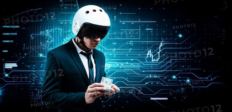 Portrait of a businessman in a suit and aviator helmet. He holds a bundle of hundred-dollar bills in front of him. Business concept.