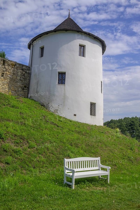Tower of the fortified village and white bench
