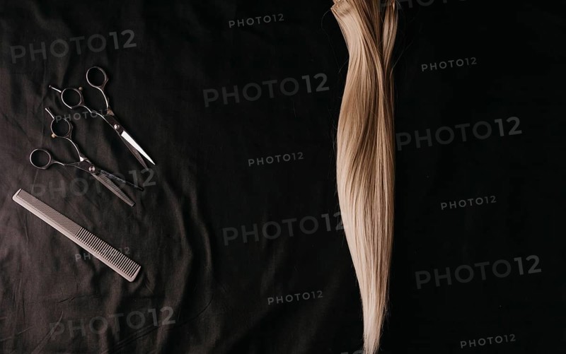 Natural hair of different colors with scissors and comb. concept of hair care and hairdressing services