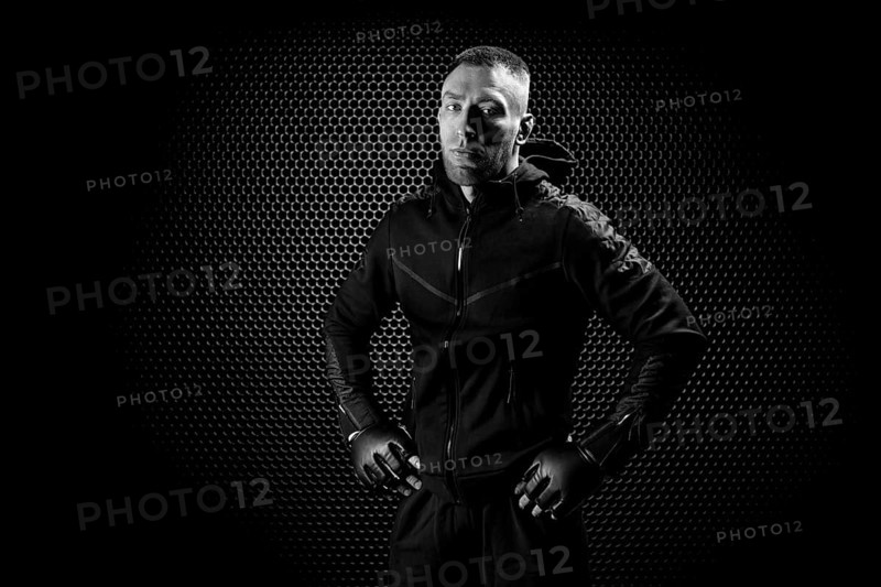 Mixed Martial Arts fighter posing on a metal grid background. Concept of mma