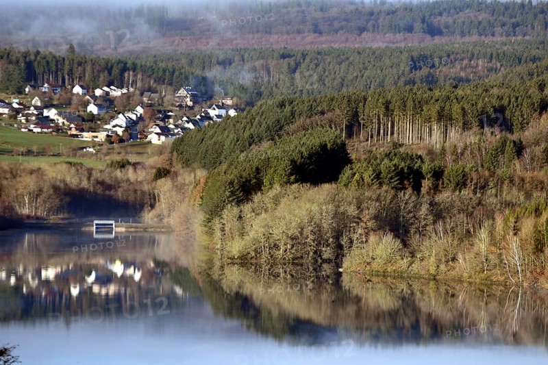 The Steinbach Dam near the national park community of Langweiler on the edge of the Hunsrueck-Hochwald National Park with fog on an early winter morning
