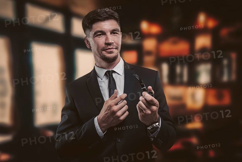 Portrait of an elegant man in a suit with a smoking pipe. Business concept.
