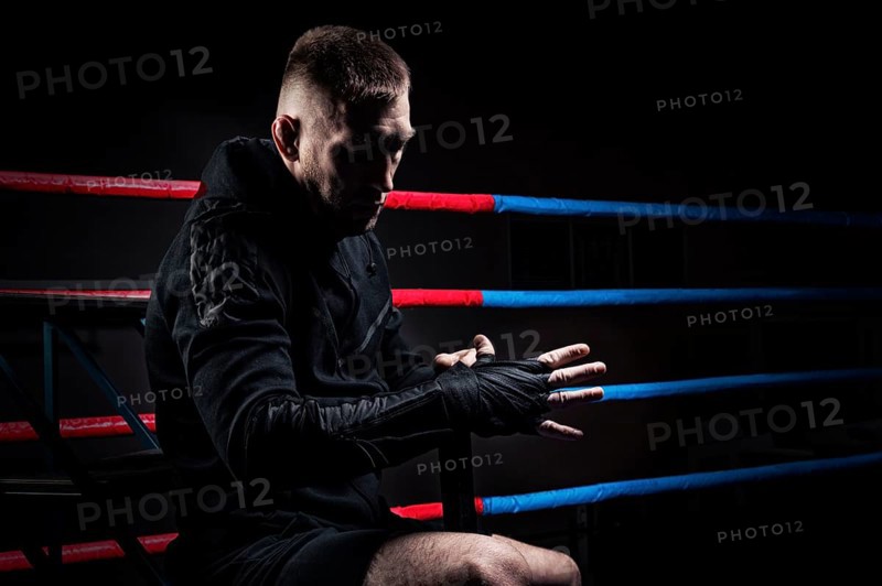 Mixed martial artist wraps bandages around his fist. Concept of mma