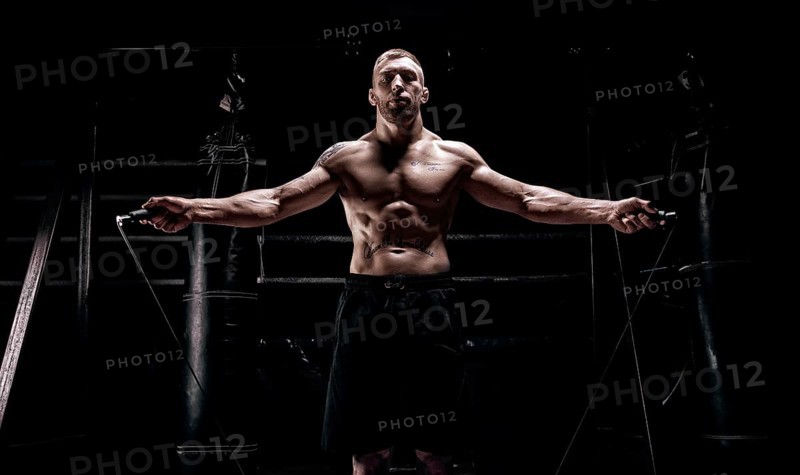 The athlete jumps on a skipping rope in the gym opposite the boxing ring. The concept of sport