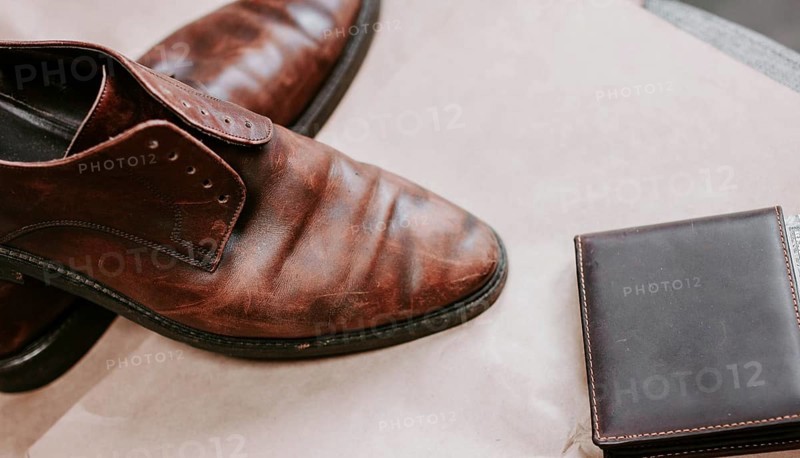 Brown men's shoes made of genuine leather and a brown leather wallet with money