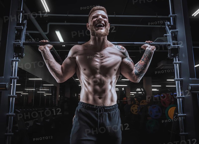 Portrait of an athlete with a barbell on the shoulders of the gym. Bodybuilding and fitness concept.