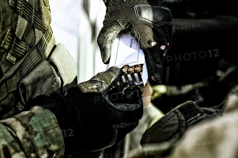 The fighter prepares a clip with bullets before the next fight.