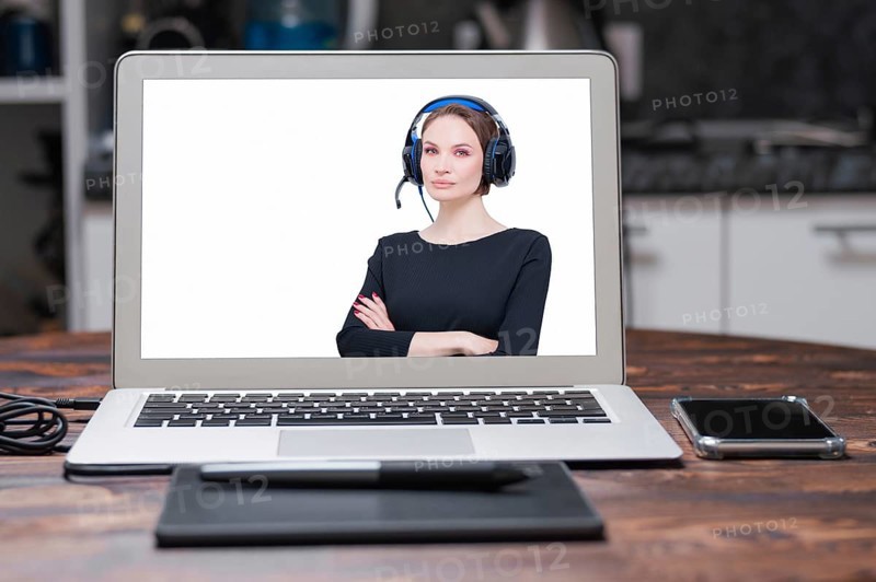 Image of a laptop with a splash screen that depicts a woman with headsets. Customer support concept.