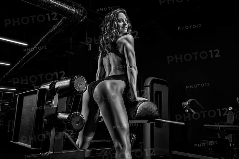 Charming brunette doing hyperextension in the gym. Back pumping. Back view. Fitness and bodybuilding concept.