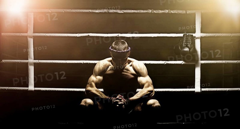 World champion in Thai boxing is sitting in the ring and getting ready for the next fight. The concept of sport
