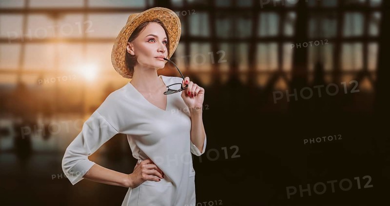 Portrait of a beautiful woman in a yellow hat standing at the airport with a passport and ticket. Travel concept.