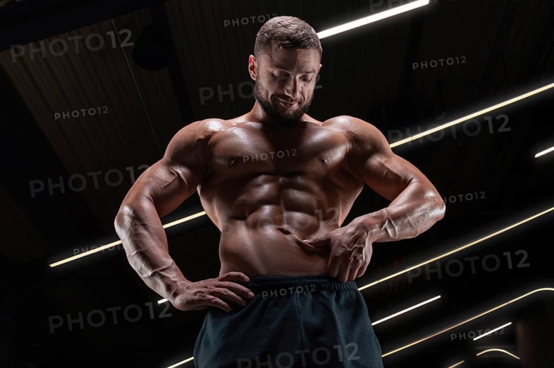 Image of a muscular guy with a naked torso and abs. Gym. Fitness concept