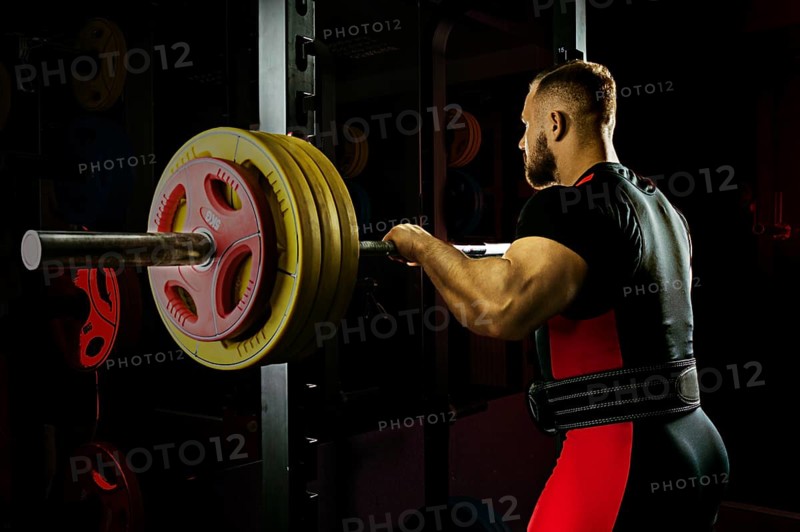 Professional athlete prepares to squat with a barbell.