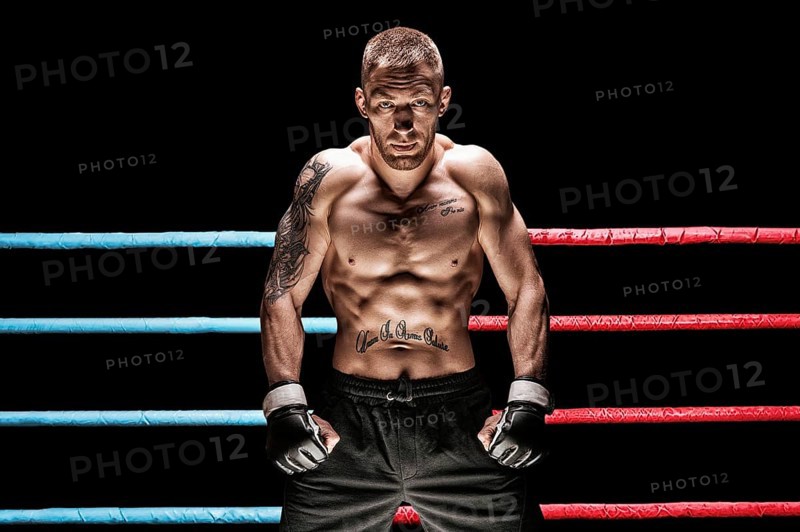 Mixed martial artist posing in boxing ring. Concept of mma
