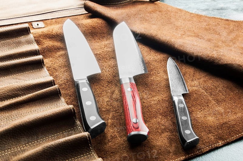 Japanese knives of different sizes from Damascus steel are in a leather case. Business concept of career growth